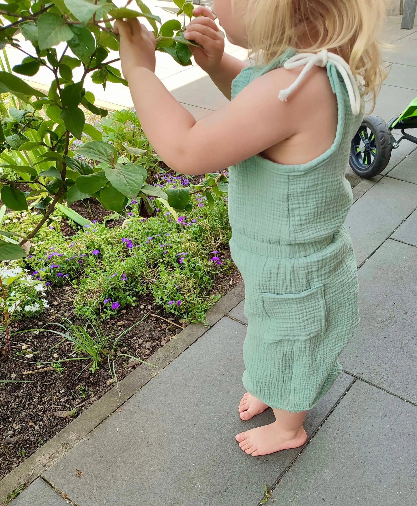 Schnittmuster Jumpsuit Pernille aus mintgrünem Musselin – Variante ohne Rüschen, Seitentasche sichtbar, Kleinkind von hinten, lange Hosenlänge, Gr. 92–98