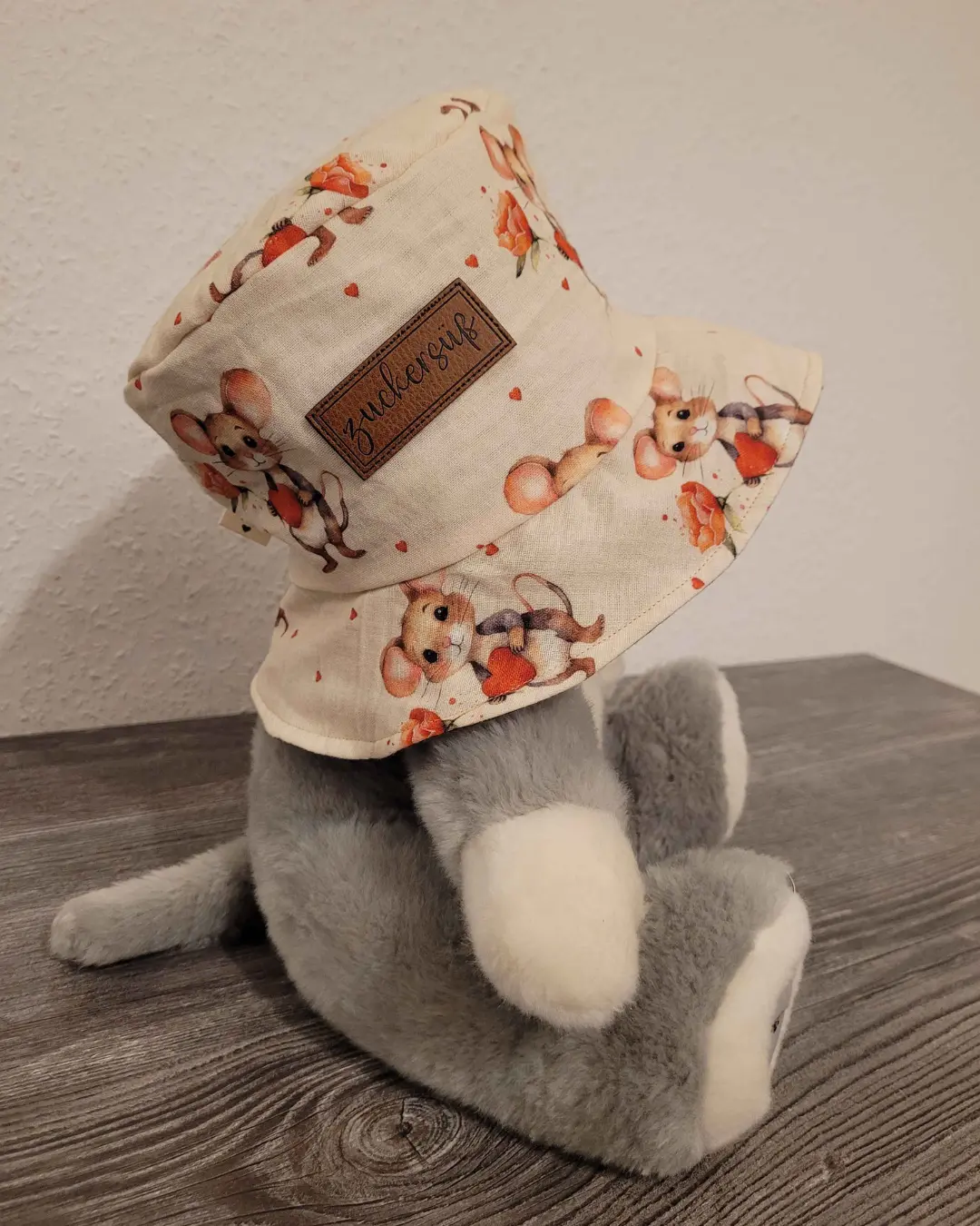 Bucket Hat Sky aus weißer Baumwollwebware mit Aquarell-Blumendruck, Mädchen trägt Fischerhut im Freien.