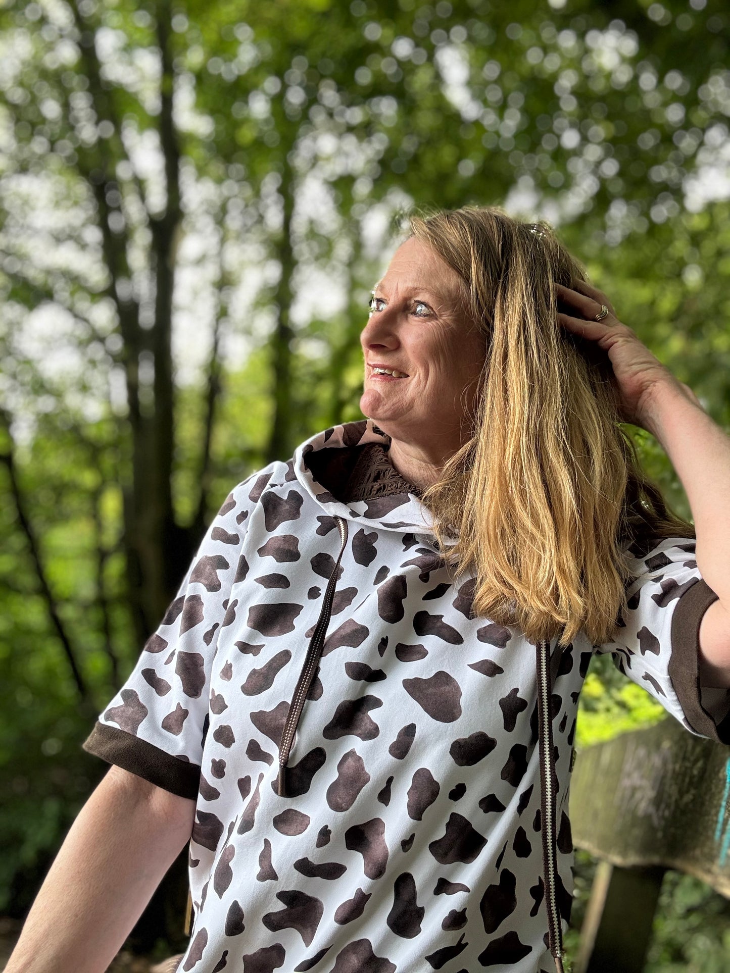 Frau im selbstgenähten Hoodie aus Cow-Print-Stoff im Freien, Design Auf der Weide von HIP SOM HAP