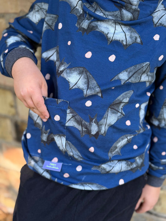 Nahaufnahme Gespensterbande Fledermaus-Jersey mit handgemalten Aquarell-Fledermäusen und rosa Punkten auf Blau