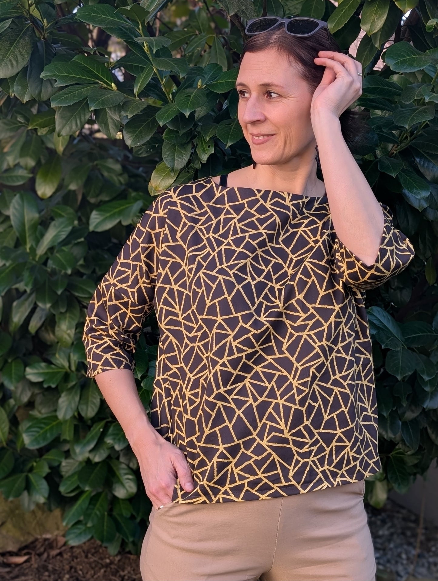 Selbst genähte Damenbluse aus geometrischem Stoff in Dunkelbraun-Gold – weiter Schnitt mit 3/4-Arm. Stoffmuster geometrisch aus der Kollektion Geometrien, Reaktivdruck Meterware, Öko-Tex Standard 100.