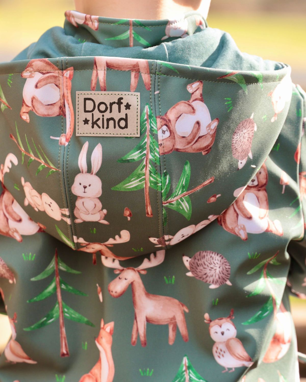 Kinderstoff Waldtiere Dunkelgrün – Detailaufnahme Kapuze einer selbst genähten Softshelljacke mit Bär, Hase, Elch und Eule. Reaktivdruck auf Öko-Tex Standard 100 zertifizierten Stoffqualitäten.