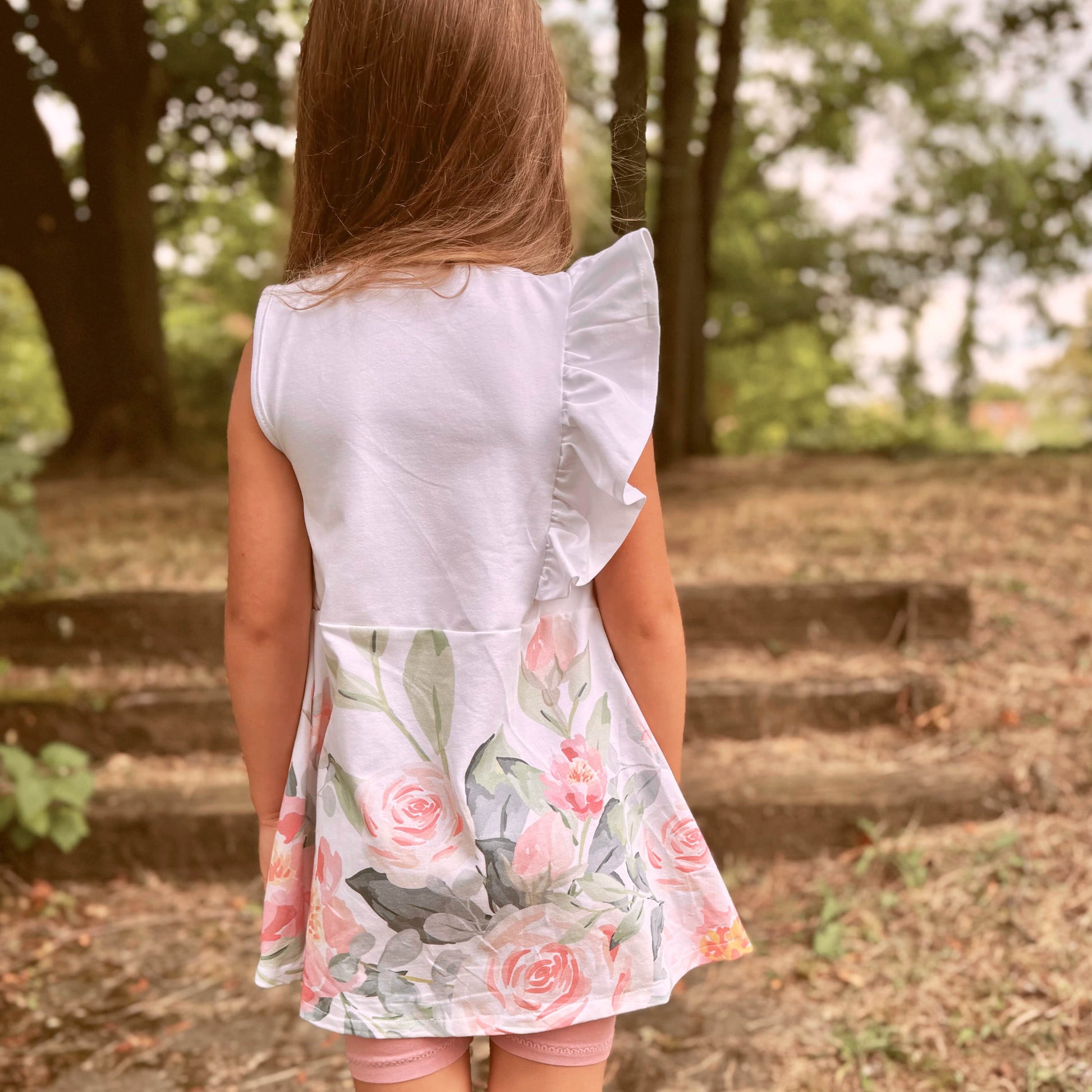 Schnittmuster Kinderkleid Mathilda Rückenansicht – weiße Webware mit Aquarell-Rosen-Bordüre, Schulterrüsche von hinten, ausgestellter Rock, Gr. 98–146