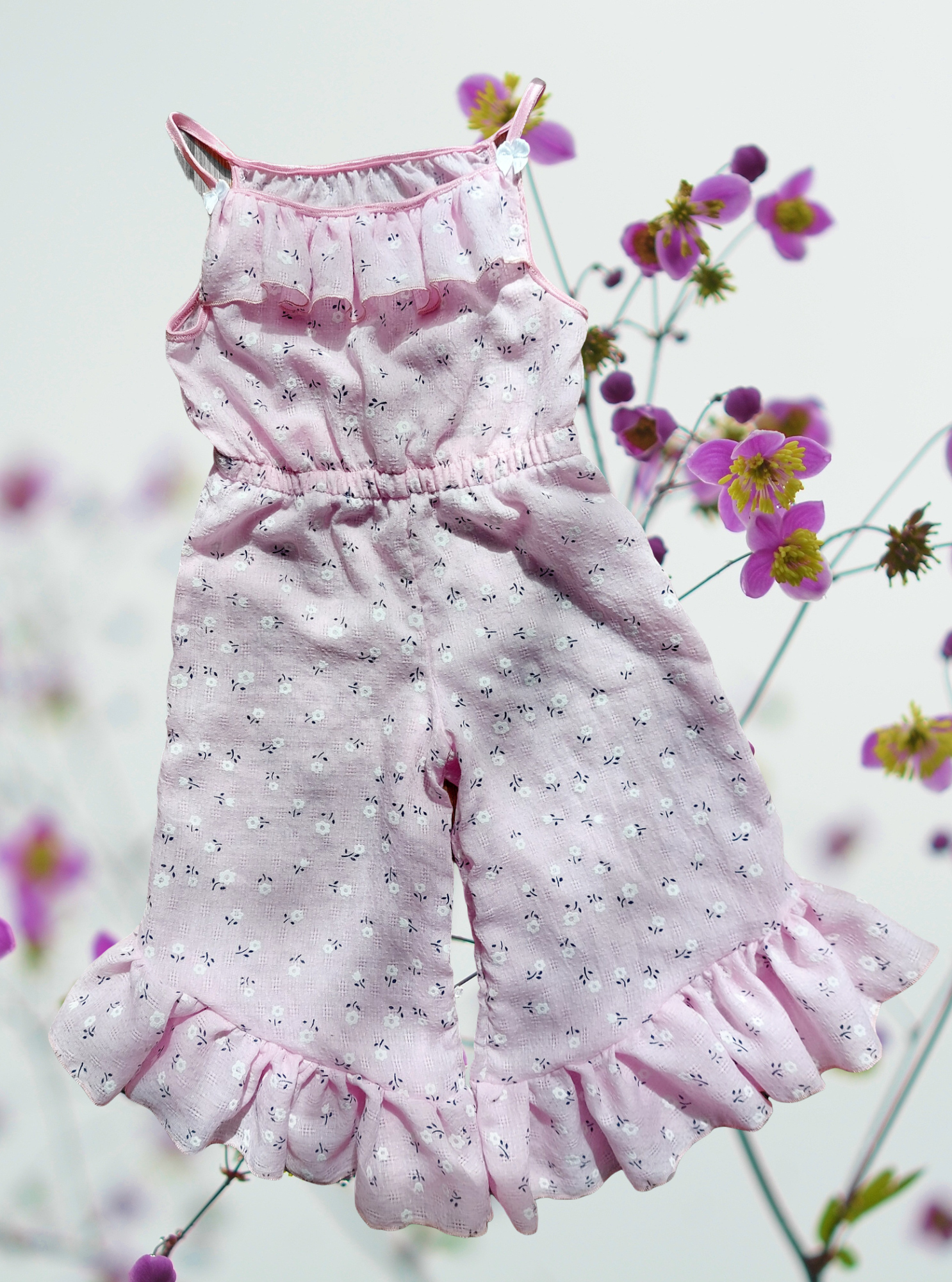 Schnittmuster Jumpsuit Pernille aus rosafarbenem Musselin mit kleinem Blumenprint – Variante mit Rüschen am Saum und Halsausschnitt, kurze Hosenlänge, Flatlay-Ansicht