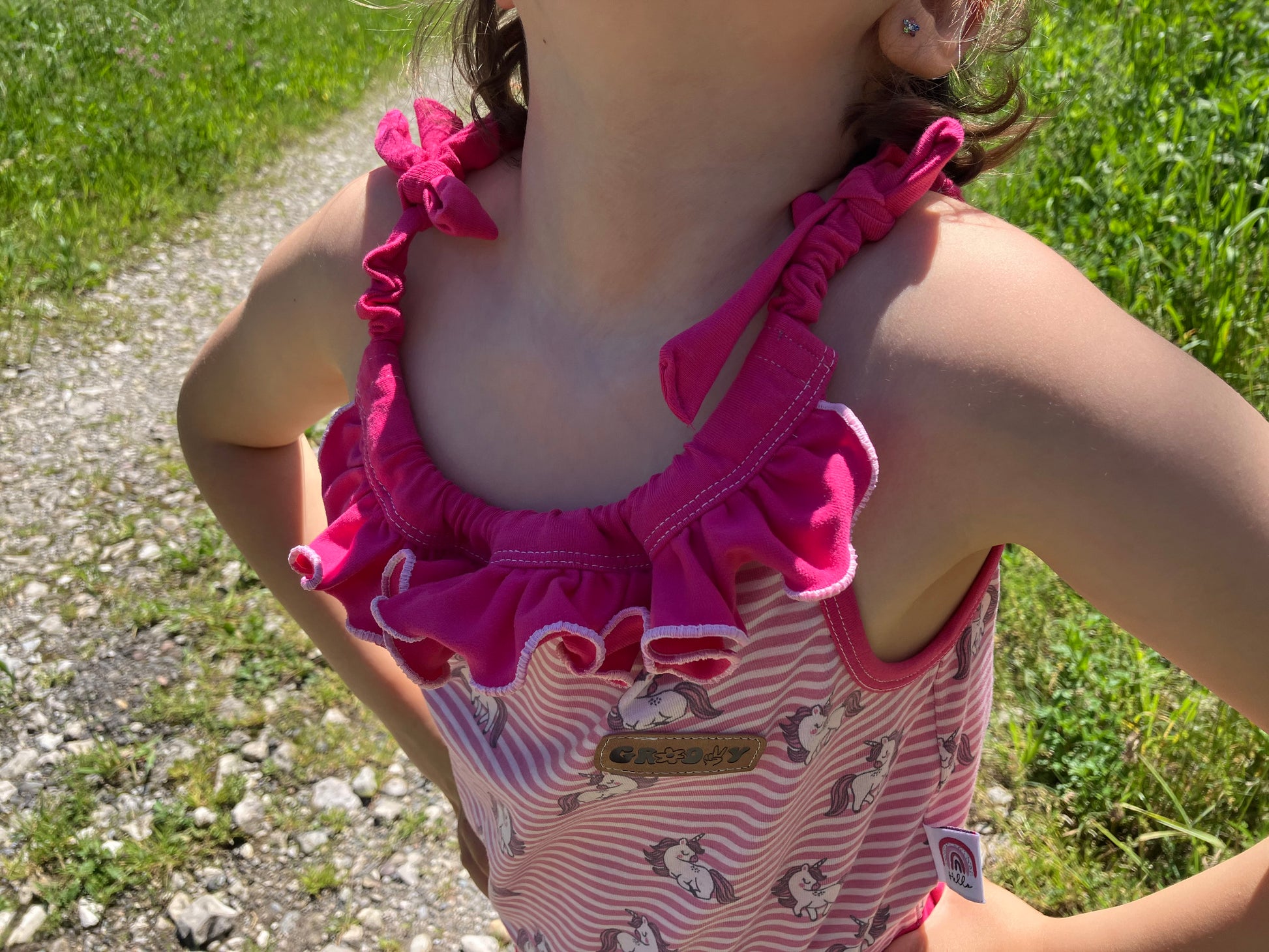 Schnittmuster Jumpsuit Pernille Detailansicht Halsausschnitt – pinker Jersey mit Rüschen-Volant, elastischer Kordelzug, Variante mit Rüschen am Ausschnitt