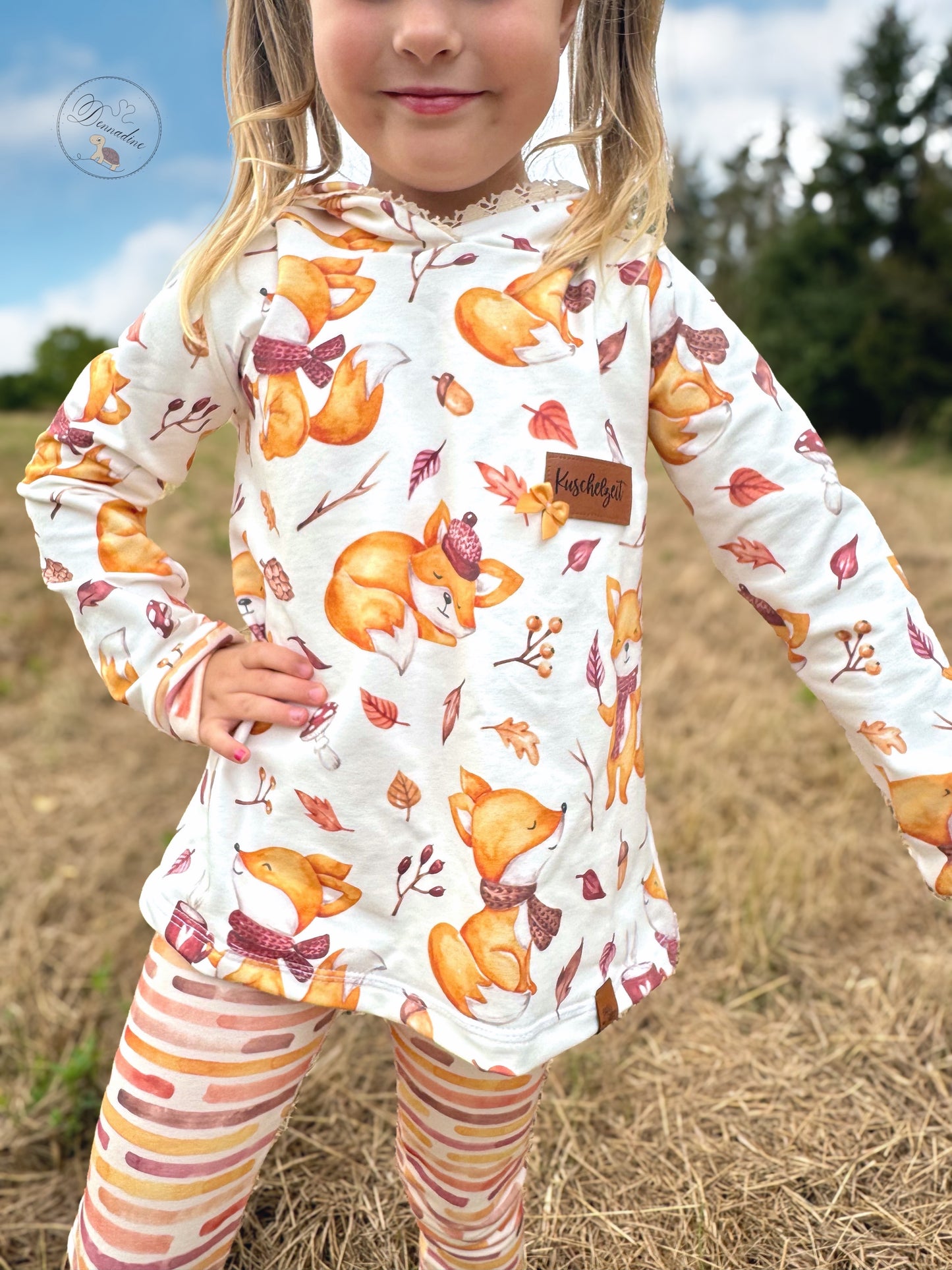 Mädchen trägt Hoodie-Kleid aus Fuchsstoff Kinder Cozy Fox mit gestreifter Leggings handgemalte Aquarell-Füchse in warmen Herbsttönen